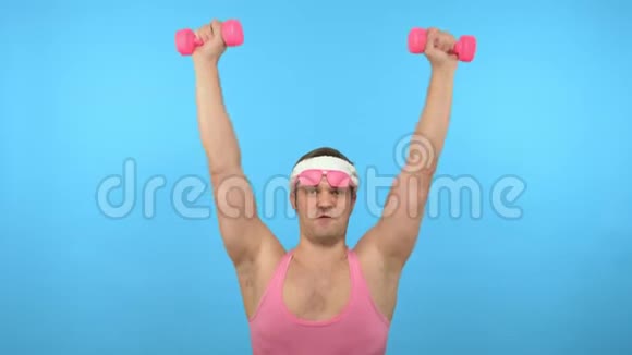 穿着粉红色衬衫的英俊男子正在与粉红色哑铃进行健身光明健身运动时尚配件视频的预览图