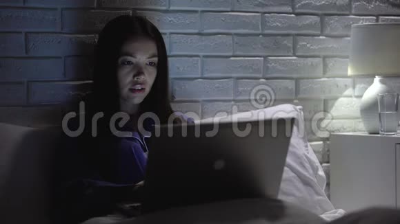 亚洲女人晚上用笔记本电脑工作喝水保持ph值平衡视频的预览图