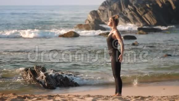 漂亮的头发女士在海边做伸展运动视频的预览图