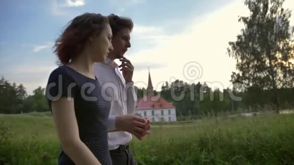 一对恋爱中的年轻夫妇在背景上与加奇纳牧师宫散步安静的公园视频的预览图
