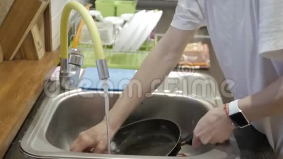 年轻女子在家洗碗女用手清洗盘收拢视频的预览图