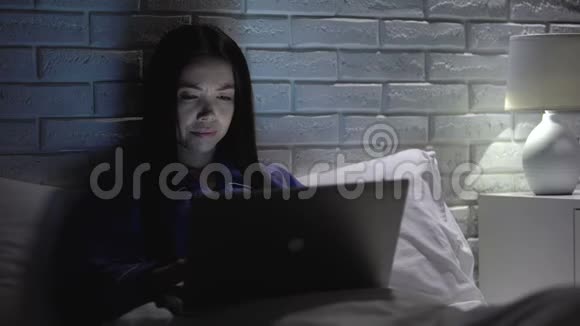 睡眠不足的亚洲女性在晚间会议的最后期限在床上工作工作时间过长视频的预览图