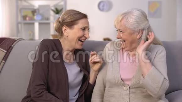 老太太们大声笑着说着坐在家里沙发上的滑稽故事视频的预览图