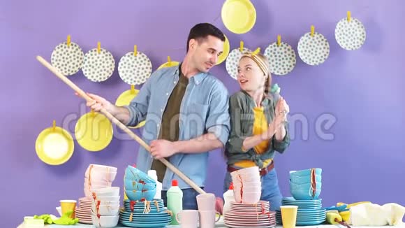 年轻的情感夫妇用画笔和扫帚跳舞唱歌视频的预览图