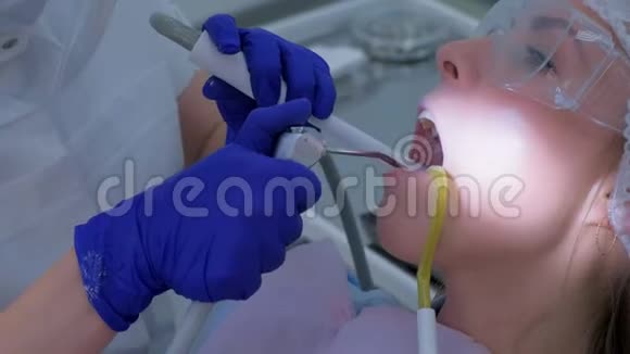 牙科保健员用超声波清洗把牙齿和水浇给妇女视频的预览图