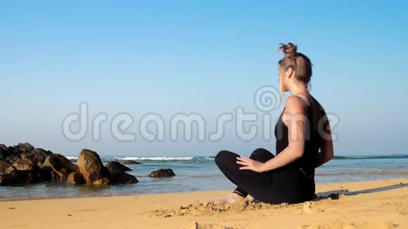 女孩在海滩和蓝色海洋上改变瑜伽姿势视频的预览图