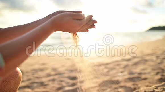 女人拿着沙子放在海滩上旅行和娱乐视频的预览图