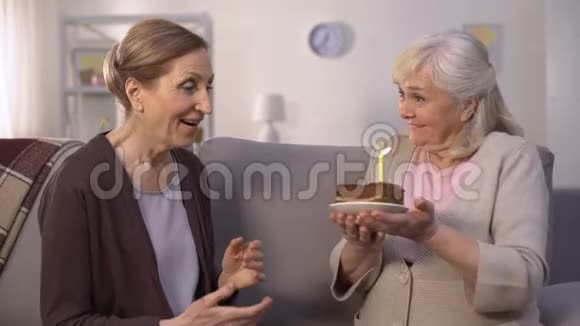 成熟的女人给姐姐送生日蛋糕快乐的女人吹蜡烛视频的预览图