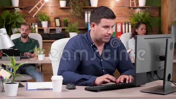 一个商人喝着咖啡在电脑上打字的肖像视频的预览图