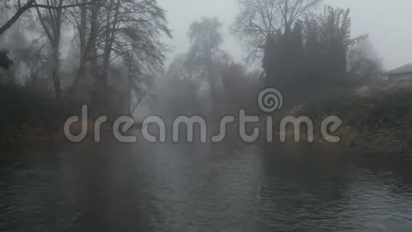 4k空中射击沿着树木和大雾环绕的河行进视频的预览图