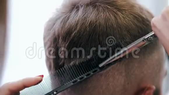 美容院用剪刀剪发的特写视频的预览图