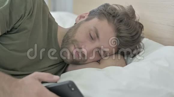 年轻人在床上用手机说话的特写镜头视频的预览图