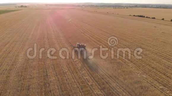 日落时分联合收割机农业机械收割黄金熟麦田的鸟瞰图收获粮食视频的预览图