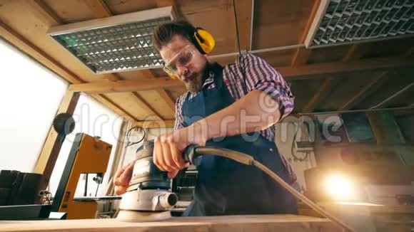 一个男木匠在打磨木块时动作缓慢视频的预览图