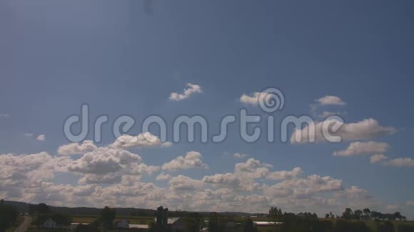 蓝色天空白色绒毛云慢慢向左向右移动农场农村在底部视频的预览图