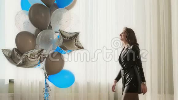 穿着黑色裙子的漂亮女孩适合蓝色气球视频的预览图