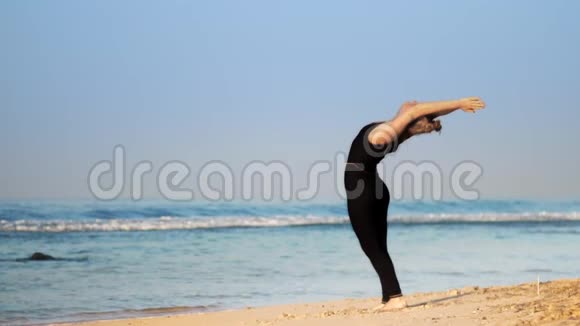 运动服中的运动女性练习瑜伽姿势半月视频的预览图