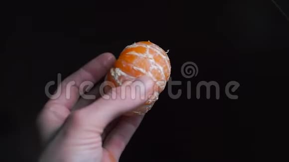 厨师手里拿着一黑色背景的剥皮橘子视频的预览图