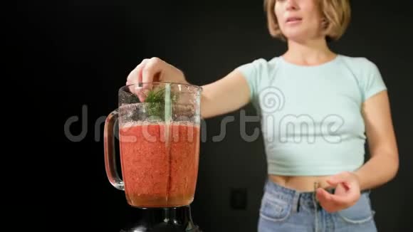 一个年轻的女人正在煮生的蔬菜她在搅拌机里加入香料视频的预览图