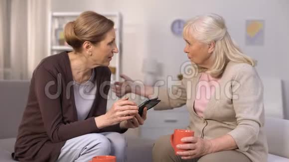 一位使用智能手机与成熟的邻居朋友交流的高级女性视频的预览图