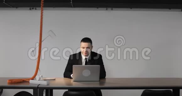 老板成熟的商人正在他在大公司的办公室里用笔记本电脑工作视频的预览图