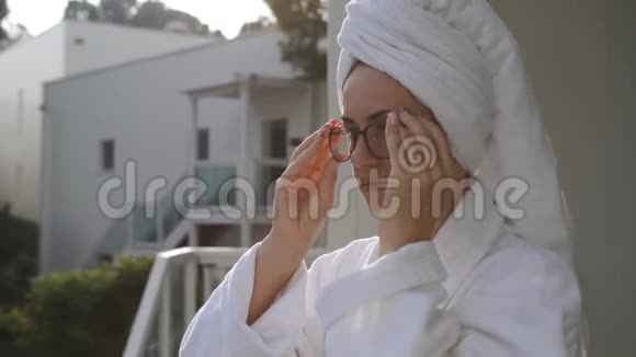 一个女人穿着浴衣站在乡间别墅的露台上享受着剩下的一切视频的预览图