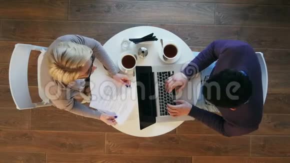 年轻的商业伙伴坐在咖啡馆的圆桌上为项目工作视频的预览图