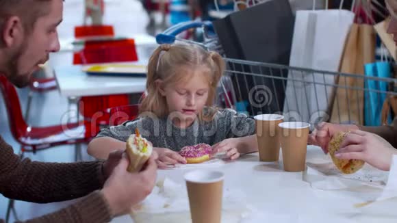 女孩在商场吃甜甜圈动作慢视频的预览图