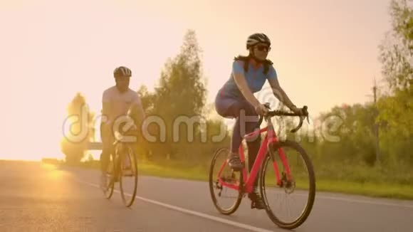 空的空间在日落时骑自行车运动的朋友一对骑自行车的人沿着海岸走自然背景下的运动小组视频的预览图