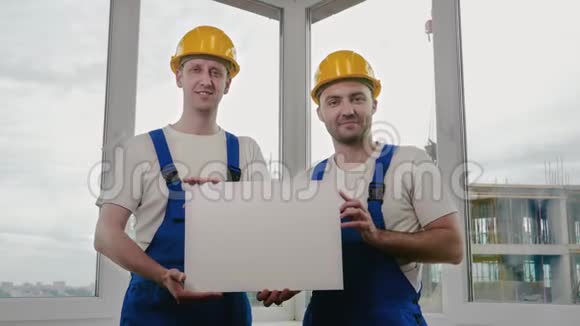 微笑的建筑工人戴着显示空白板的安全帽视频的预览图