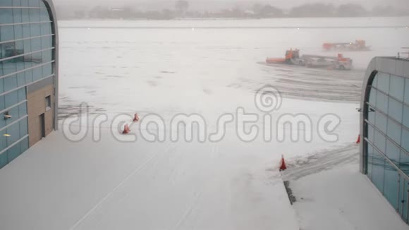 橙色雪片清洁跑道和机场停机坪有大雪天气异常航班延误视频的预览图