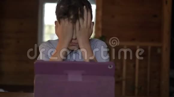 男孩坐在桌子旁用平板电脑思考视频的预览图
