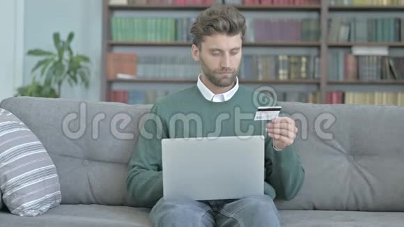 坐在沙发上在笔记本电脑上添加信用卡细节视频的预览图