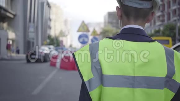 小男孩戴着安全设备和建筑工人头盔在大城市的繁忙道路上行走建筑师概念视频的预览图