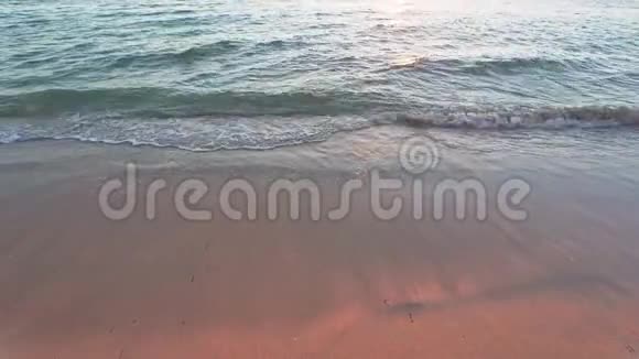 海滩附近浅海海浪上的橙色夕阳光沙色粉红红视频的预览图