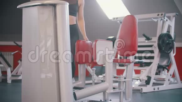 一名运动员女子在健身房训练坐在蝴蝶训练装置上开始训练视频的预览图