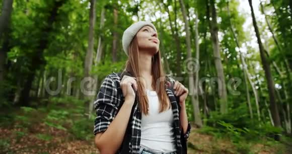 带背包气味的女人在森林里呼吸新鲜空气视频的预览图