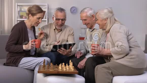老人在平板电脑上展示朋友的新项目下棋刹车公司视频的预览图
