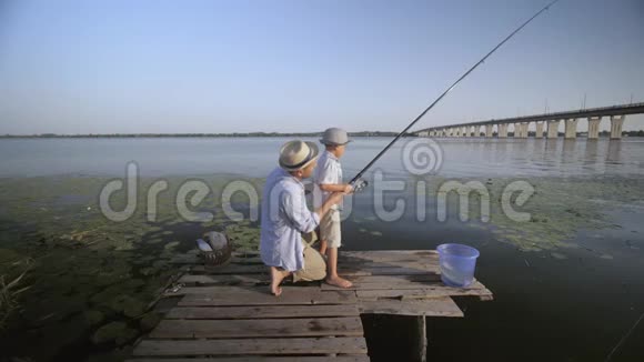 父子关系慈爱的爸爸帮助他的孩子在河边的码头上打鱼同时花钱视频的预览图