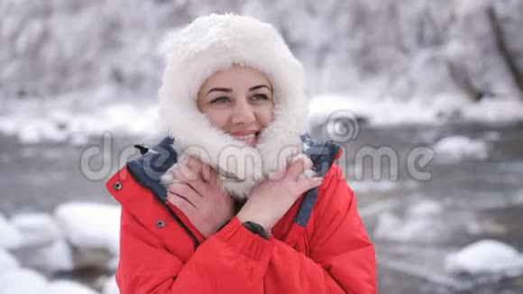 冬天的森林里幸福的女人在一条山河的岸边享受着大自然和寒冷的早晨视频的预览图