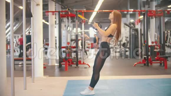 一位运动服的运动女子在健身房训练靠背握把手视频的预览图