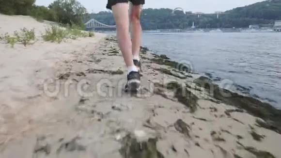 穿着黑色t恤和运动太阳镜的年轻运动员沿着河边慢跑积极主动的城市堤防男孩训练会不会视频的预览图