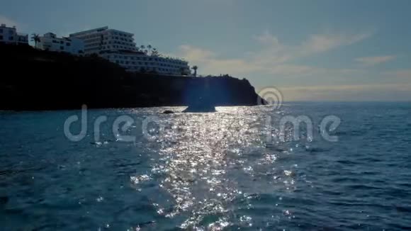 位于山上的一个旅馆综合体的剪影海水上美丽的阳光步道冷静的概念视频的预览图
