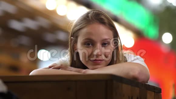 孤独可爱的女孩躺在桌子上微笑着看着你视频的预览图