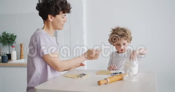母亲和儿子在厨房里用面粉做自制的饼干玩得很开心视频的预览图