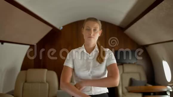 豪华私人商务飞机内的富商女士微笑着看着相机视频的预览图