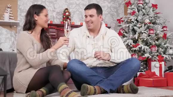 在圣诞前夜一对美丽的白种人夫妇戴着香槟碰杯视频的预览图