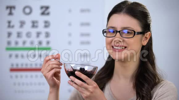 戴眼镜的快乐女士吃蓝莓保持视力维生素视频的预览图