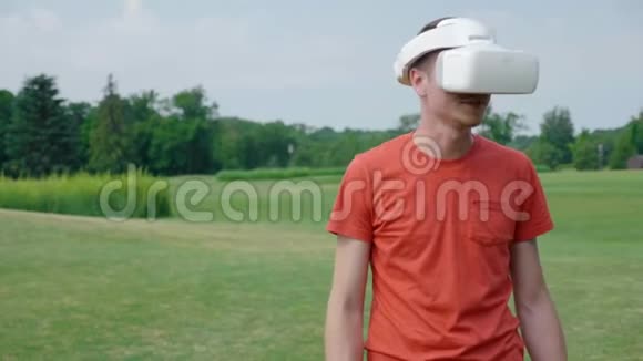 一个男人在公园里用VR耳机说话微笑视频的预览图
