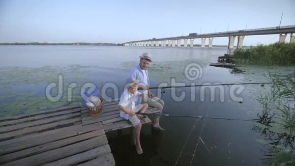 家庭假期父母和孩子的小男孩坐在一起旋转讨论他们将在码头捕鱼视频的预览图